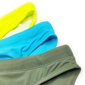 Detailed view of elastic waistbands on men's swim briefs in yellow, blue and green colors