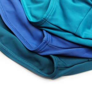 Close-up of flatlock stitching and elastic fabric on multi-color men's swim briefs