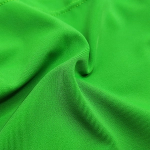 Macro shot of bright green stretch knit fabric showing detailed texture and stitching