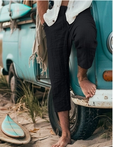 Detail of men's black drawstring waist casual shorts against a beach vacation background