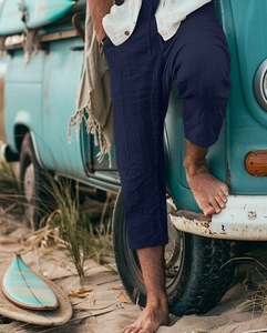 Detail of navy blue cotton linen shorts with drawstring waist in a beach setting