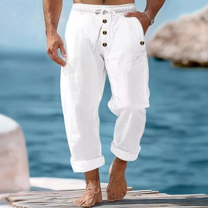 Detail of white cotton linen beach pants showing drawstring waist and button fly