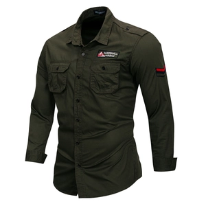 Detail of army green cotton shirt featuring chest flap pockets and embroidered badges