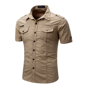Macro detail of tan military cotton shirt featuring buttoned pockets and epaulettes