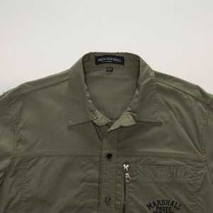 Close-up of military green outdoor shirt collar and zippered functional chest pocket