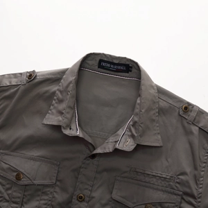 Close-up of military-style grey cotton shirt showing collar and double chest pockets