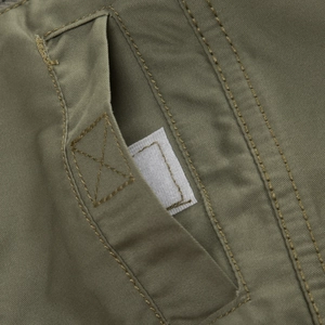 Macro detail of olive green cargo shirt pocket with durable twill fabric and velcro