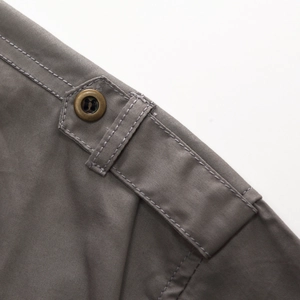 Detail of grey outdoor shirt featuring a vintage metal button and fine twill cotton fabric