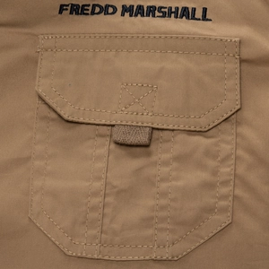 Detail of cargo pocket on khaki cotton shirt with embroidered brand logo and stitching