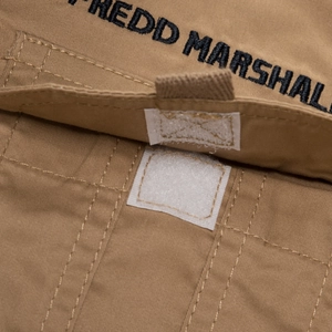 Detail of cotton shirt cargo pocket with velcro closure and black brand embroidery