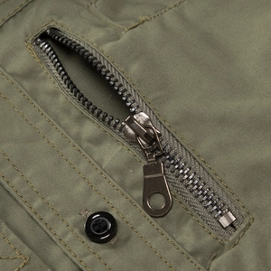 Detail of army green twill cotton fabric with metal zipper and black resin button