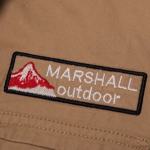 Detail of MARSHALL outdoor mountain embroidery patch on khaki cotton tactical shirt