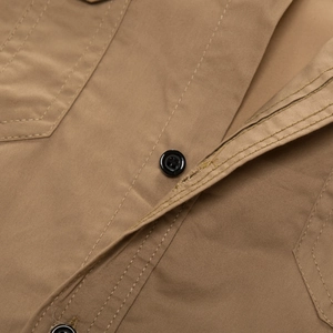 Close-up of khaki cotton shirt detail with durable stitching and black buttons