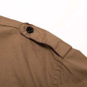 Close-up of military-style cotton twill shirt shoulder with epaulet and black button