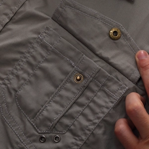Detail of durable gray twill cotton shirt with flap pocket and bronze metal buttons