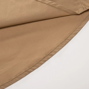 Detail shot of khaki cotton twill fabric featuring durable double-needle stitching on the hem