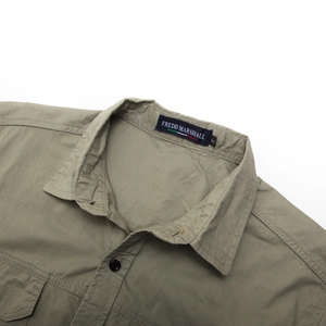 Detail of army green cotton shirt collar with brand label and reinforced double stitching