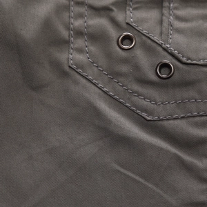 Detail of grey-green outdoor shirt featuring reinforced double stitching and metal eyelets