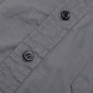 Close-up of durable gray twill cotton fabric with neat stitching and black buttons