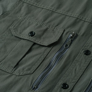 Detail of military green cargo shirt with zipper pocket and double-stitched cotton fabric