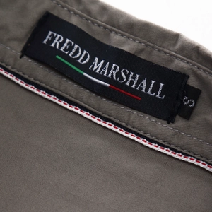 Detailed close-up of khaki military shirt collar with Fredd Marshall woven label
