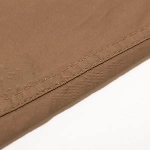 Macro detail of brown cotton twill fabric with reinforced double needle stitching seams