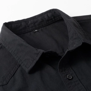 Macro shot of the collar and shoulder seams on a black 100% cotton work shirt