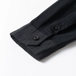 Detailed close-up of buttoned cuff on a black 100% cotton workwear shirt for men