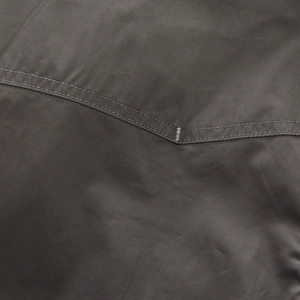 Detailed close-up of charcoal grey cotton fabric with reinforced double-needle stitching