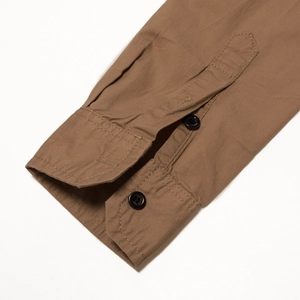 Detail of khaki cotton shirt cuff featuring double black buttons and twill fabric texture