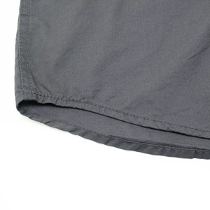 Macro shot of charcoal grey cotton fabric showing precise double-needle hem stitching detail