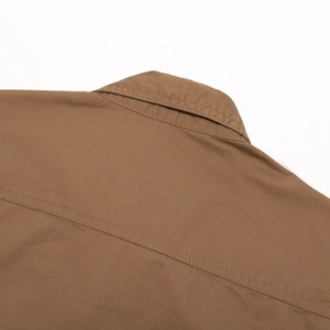 Detailed view of brown cotton shirt collar with reinforced stitching and twill texture