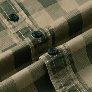 Detail of olive green plaid cotton shirt showing high-quality buttons and stitching