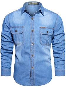 Detail of light blue denim shirt featuring chest pockets and contrast amber stitching