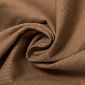 Macro view of brown cotton twill fabric showing fine texture and soft spiral folds