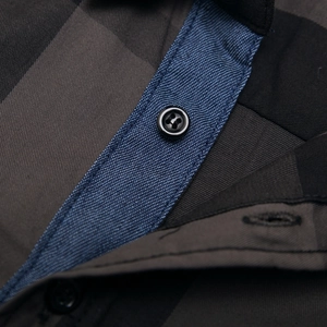 Détail de chemise à manches longues en coton avec motif à carreaux gris et col bleu texturé