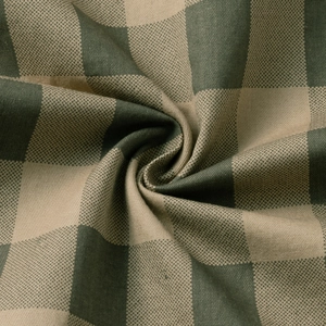 Close-up of textured cotton plaid fabric in dark green and beige with detailed weave