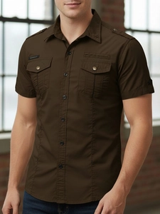 Close-up of military style dark brown cotton shirt with epaulettes and chest pockets