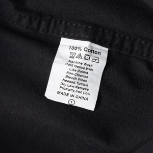 Macro shot of 100% cotton wash label and fabric texture on a black work shirt