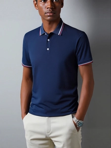 Men's slim fit navy polo shirt with striped collar and cuffs on a male model
