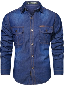 Detail of blue denim shirt showing front double pockets and orange contrast stitching