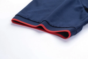 Dettaglio del polsino della polo blu navy con bordo rosso a costine e piqué