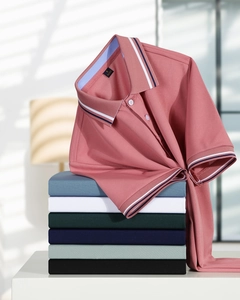 Close-up of coral pique polo shirt with striped collar and multiple color stack