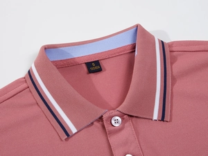 Close-up of pink pique cotton Polo shirt collar with striped trim and button detail