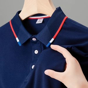 Dettaglio polo blu navy con colletto a righe tricolori e tessuto in maglia piqué