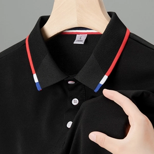 Dettaglio polo nera con colletto a righe tricolore e tessuto in mesh traspirante