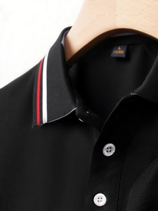 Detail view of black piqué polo collar with red, white, and blue striped webbing accents