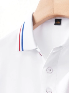 Detail of white cotton polo shirt collar featuring red and blue stripes and size L label