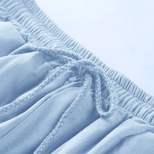 Dettaglio ravvicinato dei pantaloncini di lino azzurro con vita elastica e cordoncino