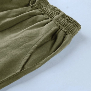 Dettaglio della vita elastica con coulisse e tasca laterale sui pantaloni di lino verde militare